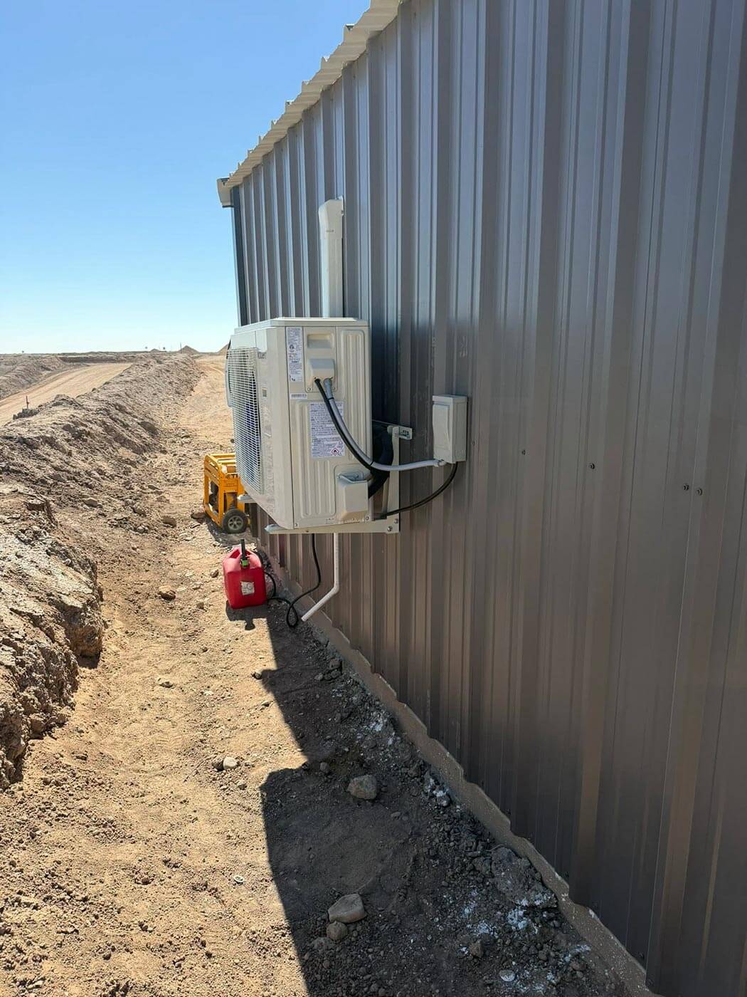 Mini split condenser installation on a metal building in the Permian Basin — K & J Services of Texas